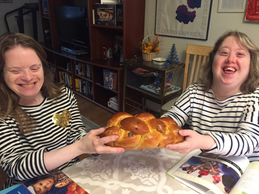 Dina and Kari happily holding Challah bread