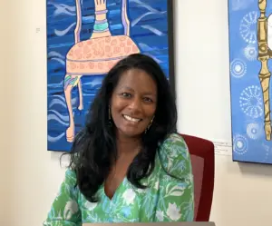 Nutan Rubinson smiling in front of JSDD artwork