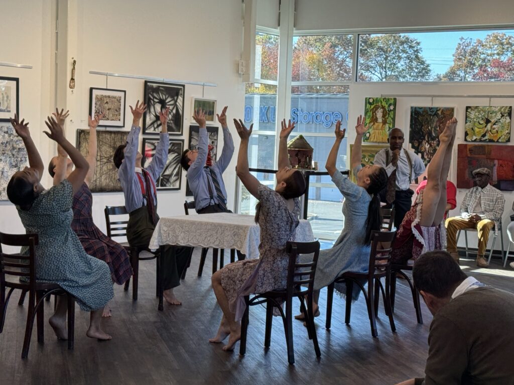 Group of people sitting around with their hands up