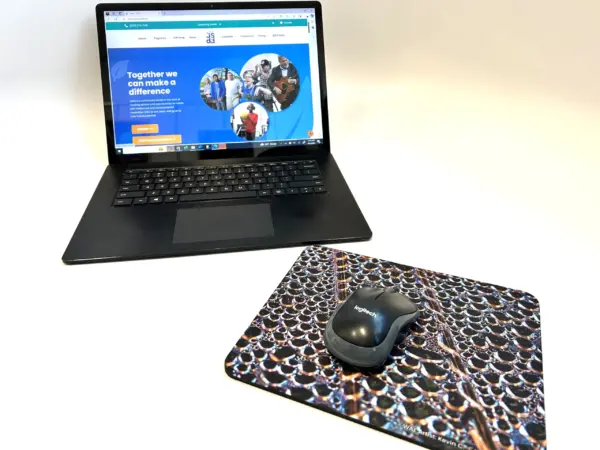 Mouse pad designed by Kevin C next to a laptop