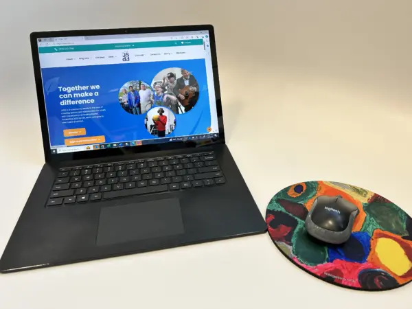 Round Mousepad designed by Yael K next to a laptop