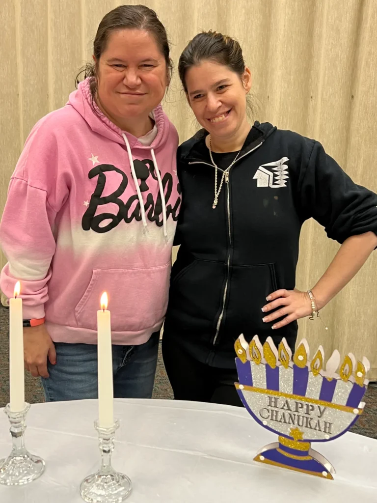 Two women smiling with lit candles